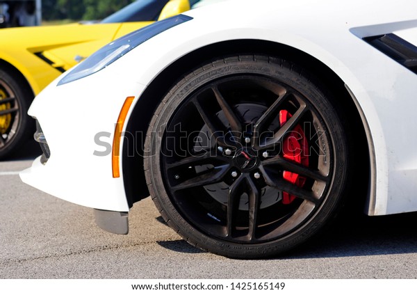 BOWLING GREEN, KY - JUNE\
16, 2018: The Michelin tire and front brakes of a white Corvette\
are seen at the National Corvette Museum Motorsports Park in\
Bowling Green,\
Kentucky.