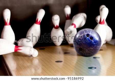 Bowling strike - ball hitting pins in the alley