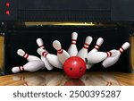 Bowling strike hit with ball hitting ten pins in the alley