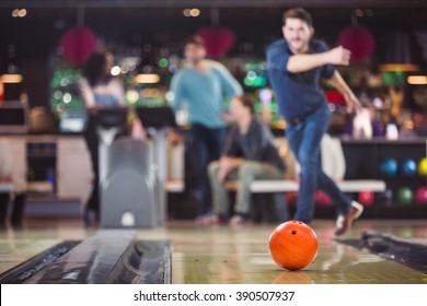 bowlingball rolls towards the pins after the throw of a man