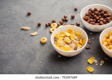 Bowls with cereals for breakfast, rings, balls and cornflakes.