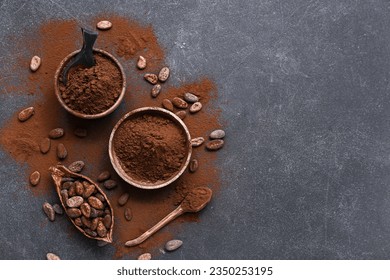 Bowls with cocoa powder and beans on black background