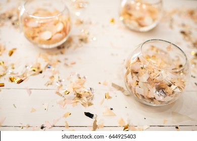 Bowls with confetti stand on white table