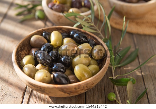 bowls with different kind of olives : green\
black kalamata olives with olive\
oil