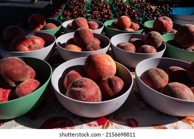 Bowls filled with whole ripe raw peaches at local farmers market