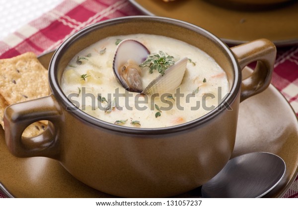 Bowls of hot delicious clam chowder\
garnished with fresh thyme, and multy grain\
crackers