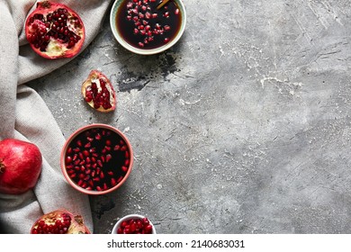 Bowls Of Pomegranate Molasses On Grey Background