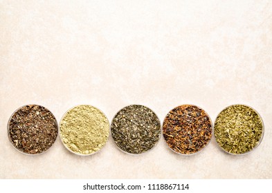 bowls of seaweed diet supplements (bladderwrack, sea lettuce, kelp powder, wakame and Irish moss) - top view on a ceramic tile with a copy space