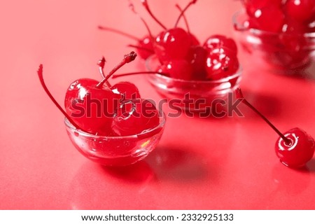 Bowls of tasty maraschino cherries on red background