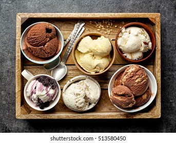 bowls of various ice creams on dark gray table, top view