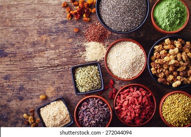 Bowls of various superfoods on wooden  background