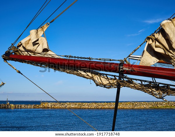 Bowsprit with the\
Danish flag and gathered sail of a large classical traditional\
vintage tall sailing\
ship