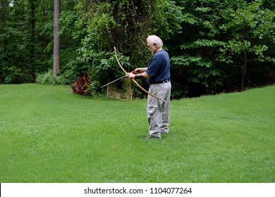 Bowyer nocks an arrow to test fire his newly crafted osage orange Indian style self bow - Powered by Shutterstock