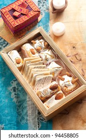 A Box Of Assorted Indian Sweets Spread Over A Traditional Printed Indian Cloth