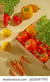 Box of assorted vegetables including yellow and red bell peppers, tomatoes, and carrots. Arranged diagonally, giving a dynamic and warm color scheme. Advertising photo