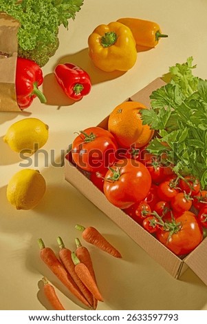 Box of assorted vegetables including yellow and red bell peppers, tomatoes, and carrots. Arranged diagonally, giving a dynamic and warm color scheme. Advertising photo
