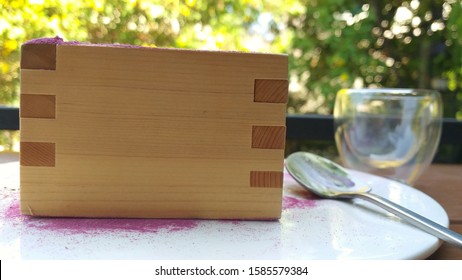 A Box Of Cake Made From Wood On The White Plate With Sloppy Spoon,classic And Retro Concept.