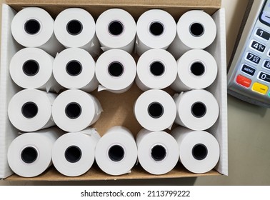 A Box Of Card Machine Paper Till Rolls On A Desk Top.