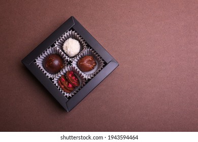 Box Of Chocolates On Brown Background. Top View, Close Up