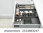 Box with cutlery in drawer indoors. Kitchen utensils storage