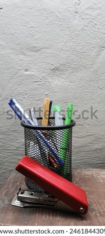 A box of different colours of pens and stepler 