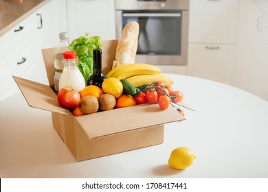 A Box Of Different Food, Fruit, Vegetables, Milk, Bread, Water, Wine On The Kitchen. Safe Home Delivery.