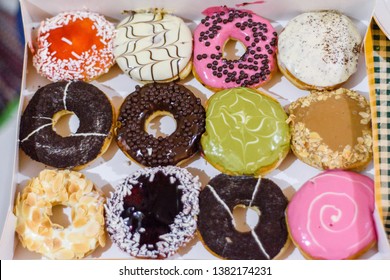 A Box Of A Dozen Colorful Donuts