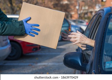 Box With Essential Supplies Given To Elderly Person At Food Distribution Point Queue