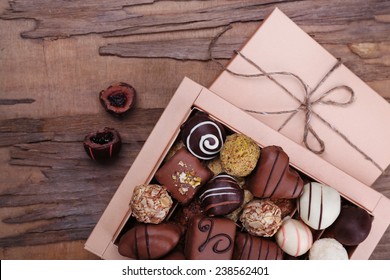 Box filled with chocolates on wooden rustic background