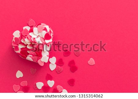 Box filled with many pink little hearts. Composition for a card with a place for text