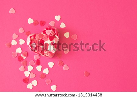 Box filled with many pink little hearts. Composition for a card with a place for text