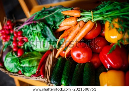 a box of fresh vegetables at the market. box with carrots, red peppers, cabbage, cucumbers and radishes