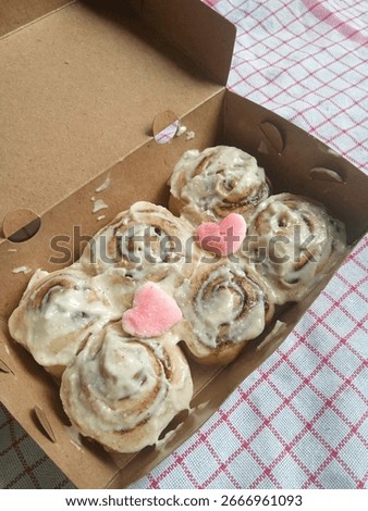 a box full of cinnamon roll bread served with cream cheese