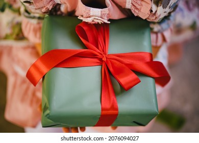 A Box With A Gift In Green Packaging Paper With Red Ribbon. Surprise Gift For New Year Or Birthday. Valentine's Day. Gift Wrapping Service.