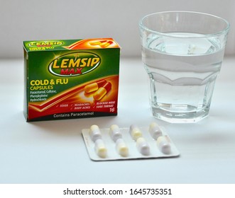 Box of Lemsip Max cold and flu tablets with glass of water and packet of unopened capsules. Popular painkiller to help alleviate flu symptoms. Edinburgh Scotland UK. February 2020