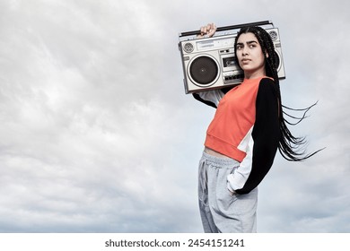 Box, outdoor or woman with radio music in cool outfit or retro fashion in city and downtown urban area. Biracial female dancer, disco song audio and gen z girl with vintage style or funky clothes - Powered by Shutterstock