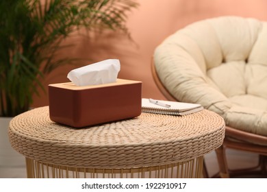 Box with paper tissues on table in room