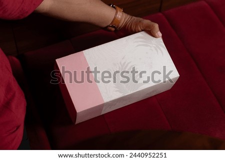 
A box for plain pink and white shoes with floral motif.