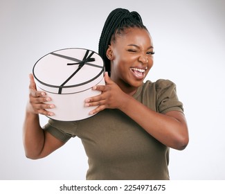 Box, present and portrait of black woman on studio background. Happy female, present and package with wink for birthday, excited celebration and promotion to celebrate happiness, giveaway and smile - Shutterstock ID 2254971675