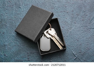 Box with stylish keys and keychain on dark background - Powered by Shutterstock