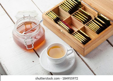 Box With Tea Bag On Wooden Table, Tea Cup, Honey