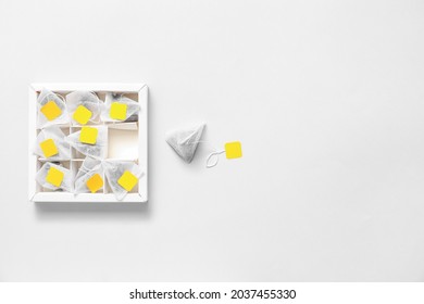 Box with tea bags on light background
