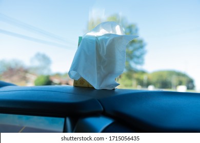 A Box Of Tissue Sitting On The Dash Of A Car With The Sun Shining Through.