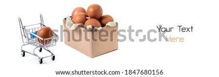Box and trolley with one egg isolated on white background, shopping and buying food metaphor concept.