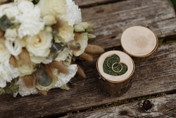 A Box For Wedding Rings Made Of Wood With Floral Decor Lies On A Wooden Surface. Wedding Accessories.