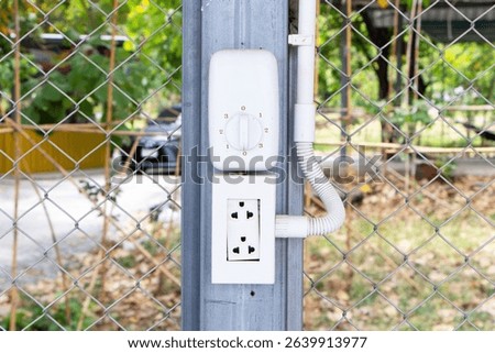 Box white electrical power switch off, on and plug energy, Fan control Turn OnOff with plastic pipe for electrical wiring attached to steel pole. Electrical technology safety concept.