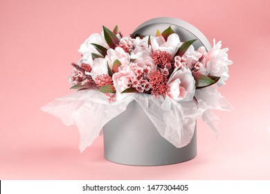 A box with white tulips and ornamental plants on a pink background. Spring flowers.  Place for text.  - Shutterstock ID 1477304405