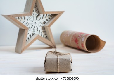 Box wrapped in craft paper scandinavian style with a star and a craft paper roll
