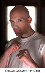 The boxer, a bald young man posing as a boxer with an angry look and white knuckles