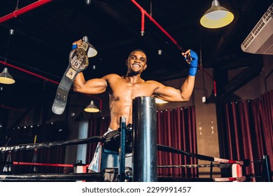 Boxer with Champion belt celebrating flawless victory. Boxing fighters training at gym - Powered by Shutterstock